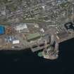 Oblique aerial view of Invergordon harbour and oil rig service base, looking N.