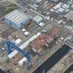 Oblique aerial view of Rosyth Naval Dockyard showing the construction of an aircraft carrier, looking NW.