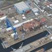 Oblique aerial view of Rosyth Naval Dockyard showing the construction of an aircraft carrier, looking NW.