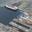 Oblique aerial view of Rosyth Naval Dockyard showing the construction of two aircraft carriers, looking W.