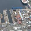 Oblique aerial view of Rosyth Naval Dockyard showing the construction of an aircraft carrier, looking S.