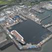 Oblique aerial view of the Main Basin, Rosyth Naval Dockyard showing the construction of two aircraft carriers, looking NE.