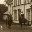 Portrait of two figures on horseback and a small terrier in front of the entrance to Canaan Lodge, Edinburgh.
