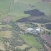 Oblique aerial view of Tamnavulin Distillery and Tombae Roman Catholic Church of the Incarnation, looking SW.