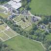 Oblique aerial view of Mortlach Parish Church, burial gounds and watch house, looking W.