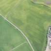 Oblique aerial view of the cropmarks of the ring ditch house and the pits, looking E.