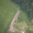 Oblique aerial view of the cropmarks of the fort and the Glasgow University excavation trench, looking ESE.