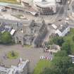 Oblique aerial view of the Memorial to King Edward VII, Thomson's Court, Holyrood Palace Gatehouse, Holyrood free Church and School, Abbey Sanctuary and Holyrood Palace Yard Fountain,  looking SW.