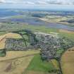 General oblique aerial view of Leuchars village and airfield with the Eden Estuary Nature Reserve beyond, looking SE.