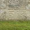 Detail of carved grave slab (MB 1613) set into base of south wall of church.