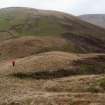 A view looking NE of the Roman watch tower at the pass of Ewes Doors, with Ewenshope Fell in the background. A tripod marks the centre of the site, and Mr Adam Welfare is standing on the outer bank.