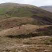 A view looking NE of the Roman watch tower at the pass of Ewes Doors, with Ewenshope Fell in the background. A tripod marks the centre of the site, and Mr Adam Welfare is standing on the inner bank.