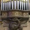 Nave. Detail of gryphon carving under organ pipes.