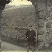 View of Neidpath Castle entrance gateway, with man carrying photographer's bag
