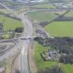 Oblique aerial view of the A90 road junction and Newbigging Steading, looking ESE.