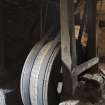 Interior. Basement or undercroft level, view of wooden drive drum and sawbench drive belts