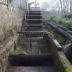 Waterwheel and lade system, view from south west with debris grill across the concrete launder