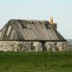 General view of 19th century single storey cottage with remains of plended tarred felt roof, Balemartine, Tiree.