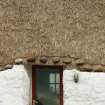 View of door showing thatching and stone weights; restored19th century thatched cottage, Tiree, Kilmoluaig.