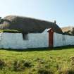 View of 2 restored 19th century single storey thatched cottages with traditional marram roofing, Tiree, Balevullin.