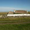 View of  restored 19th century single storey thatched cottage and byre with traditional marram roofing, Tiree, Balevullin.