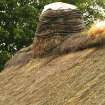  Detail of  thatched roof showing ridge  and rope supports around chimney; cruck-framed cottage, Torthorwald.