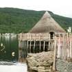 Side view of reconstructed crannog showing thatched roof;  Croft-na-Caber Loch Tay.
