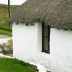 View of cottage with stone weights below thatch; Totscore, Skye.