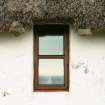 View of thatch with stone weights above window; Totscore, Skye.