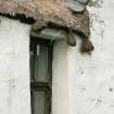 Detail of thatching with lead skew and stone weights above window; Totscore, Skye.