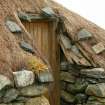 Detail of stone weights on thatch over doorway of outbuilding; Reumisgarry, North Uist.