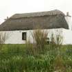 Front view of thatched cottage showing scobed ridge; 10 Uachdar, Benbecula.