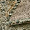 Detail of weighted thatch beside chimney stack on renovated cottage;  Rhugha Sinish, South Uist.