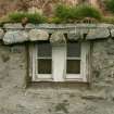 Detail of weighted thatch over window;  99 Carnan South Uist.
