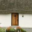 Detail of thatched roof with rope over doorway;  51 Balgarva, Eochar, South Uist.