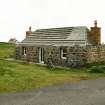 View of 19th century cottage, formerly with 'muran thatch roof' now in process of re roofing; 153 Howmore, South Uist.