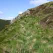 Looking W along the rampart to the outcrop at the SE of the fort