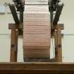 Interior. General view. Jaquard loom in gallery area. View of cut or punch cards. The holes and blanks on the cards allow the hooks in the frame to select or not select threads to create the complex patterns in the cloth
