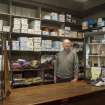 Portrait of Mr Alexander Hunter at his shop counter