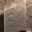 Obliquely lit view of medieval cross slab fragment (with scale).