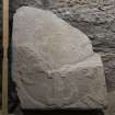 Obliquely lit view of medieval cross slab fragment (with scale).