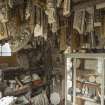 Interior. South range, ground floor, Showroom, west end. View of samples including swags and small medallion plaques in a late Victorian display cabinet. Also, note the patterns hanging from ceiling - these are the master patterns used to create a mould from which multiple plaster casts can be taken