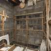 Interior. North drying room situated at north end of east range. View showing racks. Workroom beyond wall to the right