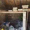 Shed on west side of courtyard, view showing scaffold planks and materials