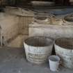 North end of courtyard. Lime pit, view showing half wooden barrel mixing vessels and two-handled bucket