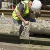 Detail of workman removing coping stone.