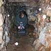 Archaeologist Gemma Hudson preparing equipment for the laser scan survey inside Cracknie souterrain, Tongue