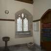 Entrance hall, general view showing door to north transept now used as shelving and old font.