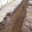 Building 3. W foundation trench. Concrete slab overlying brown sand, facing N