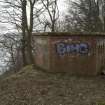 NE Blockhouse from north. Showing angled walls and grafitti tagging. Inchcolme Island is on the horizon through trees.